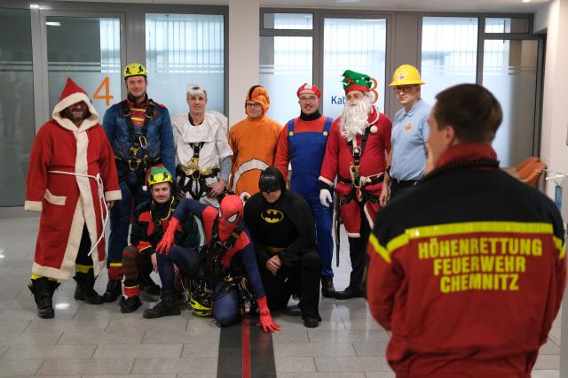 06 December 2025, Saxony, Chemnitz: Members of the Chemnitz fire department's height rescue team stand together in costume at the hospital. For the past five years, fire department rescuers have been organizing an abseiling campaign at children's hospitals across Germany on St. Nicholas' Day and delighting patients and staff with small gifts. Photo: Sebastian Willnow/dpa