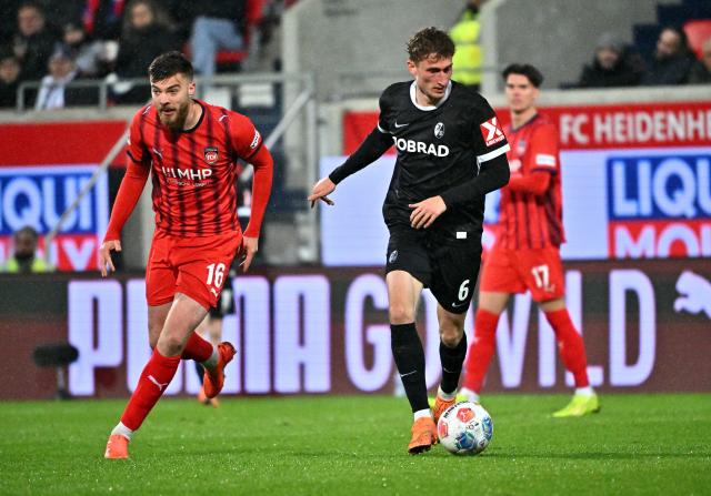 06 December 2025, Baden-Württemberg, Heidenheim: Freiburg's Patrick Osterhage (R) in action against Heidenheim's Julian Niehues during German Bundesliga soccer match between FC Heidenheim and SC Freiburg at the Voith-Arena. Photo: Jan-Philipp Strobel/dpa - IMPORTANT NOTICE: DFL and DFB regulations prohibit any use of photographs as image sequences and/or quasi-video.