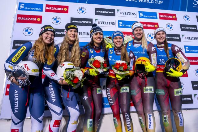 06 December 2025, North Rhine-Westphalia, Winterberg: (L-R) Austria's second-placed team of Lara Michaela Kipp and Selina Egle, Germany's winning team of Jessica Degenhardt and Cheyenne Rosenthal and the third-placed team of Dajana Eitberger and Magdalena Matschina stand on the podium after the Women's doubles competition of the Luge World Cup in Winterberg. Photo: David Inderlied/dpa