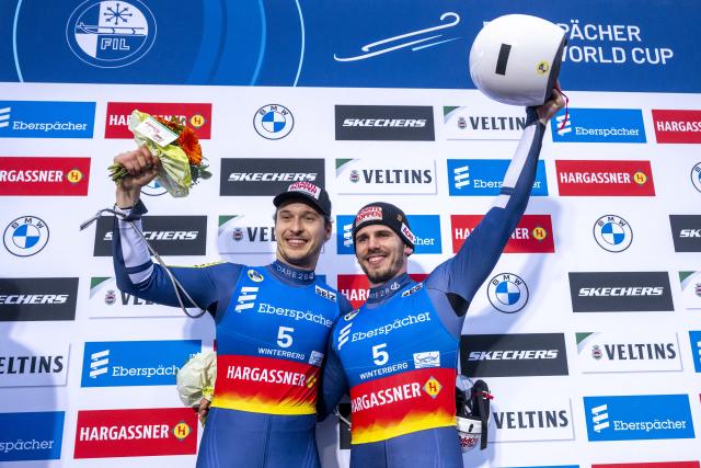 06 December 2025, North Rhine-Westphalia, Winterberg: Austria's winning team of Juri Thomas Gatt and Riccardo Martin Schoepf celebrates their victory after the men's doubles competition of the Luge World Cup in Winterberg. Photo: David Inderlied/dpa