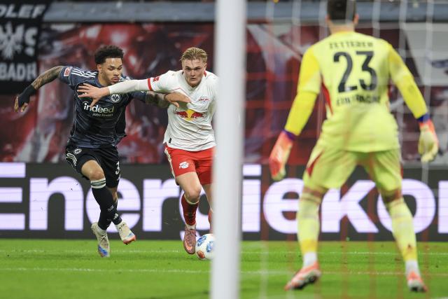 06 December 2025, Saxony, Leipzig: Leipzig's Conrad Harder and Eintracht Frankfurt's Nnamdi Collins in action during the German Bundesliga soccer match between RB Leipzig and Eintracht Frankfurt at the Red Bull Arena. Photo: Jan Woitas/dpa - IMPORTANT NOTICE: DFL and DFB regulations prohibit any use of photographs as image sequences and/or quasi-video.