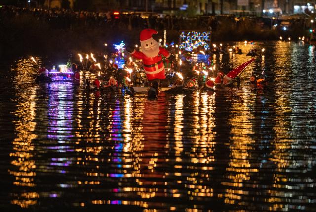06 December 2025, Rhineland-Palatinate, Bernkastel-Kues: Torchlight swimmers float down the Moselle on St. Nicholas Eve. Photo: Harald Tittel/dpa