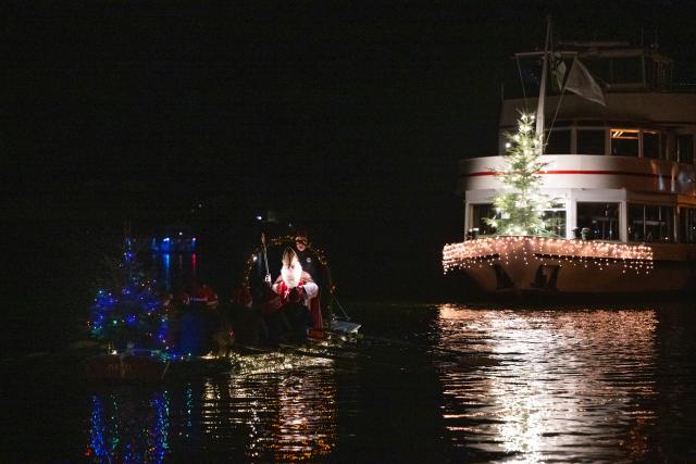 06 December 2025, Rhineland-Palatinate, Bernkastel-Kues: A man dressed as Santa Claus crosses the Moselle in a boat to give children chocolate. Photo: Harald Tittel/dpa