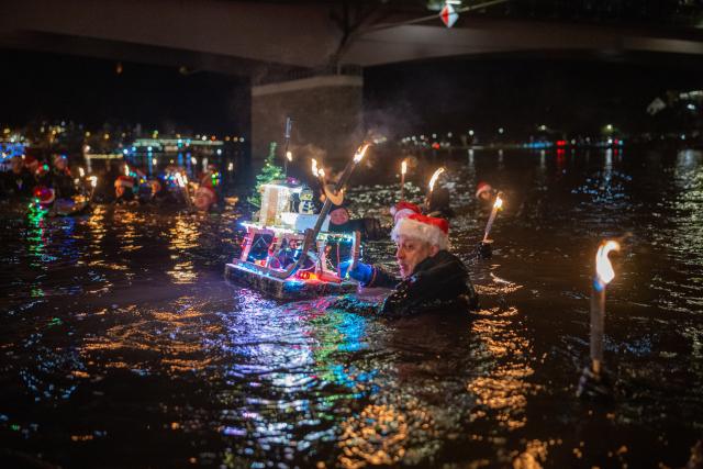 06 December 2025, Rhineland-Palatinate, Bernkastel-Kues: Torchlight swimmers float down the Moselle on St. Nicholas Eve. Photo: Harald Tittel/dpa