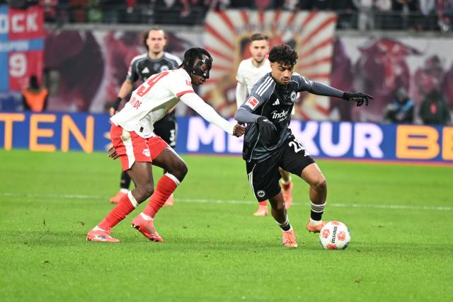 06 December 2025, Saxony, Leipzig: Leipzig's Yan Diomande and Eintracht Frankfurt's Nathaniel Brown battle for the ball during the German Bundesliga soccer match between RB Leipzig and Eintracht Frankfurt at the Red Bull Arena. Photo: Jennifer Brückner/dpa - IMPORTANT NOTICE: DFL and DFB regulations prohibit any use of photographs as image sequences and/or quasi-video.