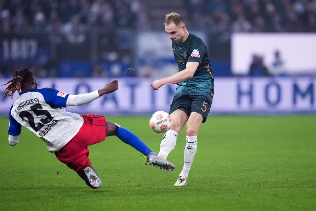 07 December 2025, Hamburg: Hamburger's Jordan Torunarigha (L) and Werder Bremen's Amos Pieper battle for the ball during the German Bundesliga soccer match between Hamburger SV and SV Werder Bremen at the Volksparkstadion. Photo: Marcus Brandt/dpa - IMPORTANT NOTICE: DFL and DFB regulations prohibit any use of photographs as image sequences and/or quasi-video.