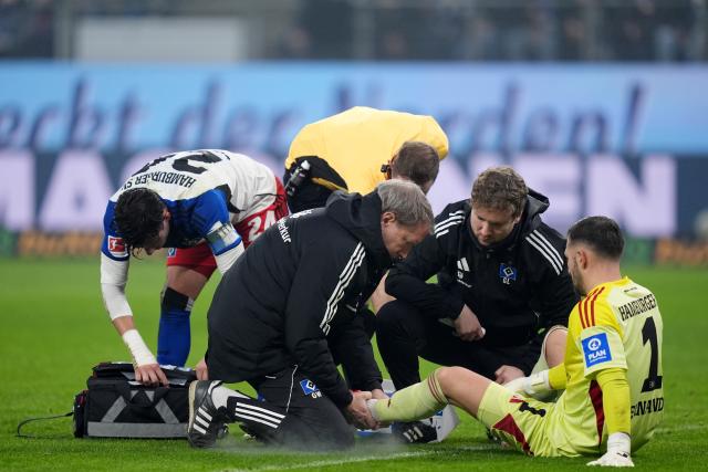 07 December 2025, Hamburg: Hamburger goalkeeper Daniel Heuer Fernandes receives medical treatment during the German Bundesliga soccer match between Hamburger SV and SV Werder Bremen at the Volksparkstadion. Photo: Marcus Brandt/dpa - IMPORTANT NOTICE: DFL and DFB regulations prohibit any use of photographs as image sequences and/or quasi-video.