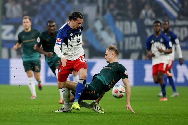 07 December 2025, Hamburg: Hamburger's Rayan Philippe (L) and Werder Bremen's Amos Pieper battle for the ball during the German Bundesliga soccer match between Hamburger SV and SV Werder Bremen at the Volksparkstadion. Photo: Christian Charisius/dpa - IMPORTANT NOTICE: DFL and DFB regulations prohibit any use of photographs as image sequences and/or quasi-video.