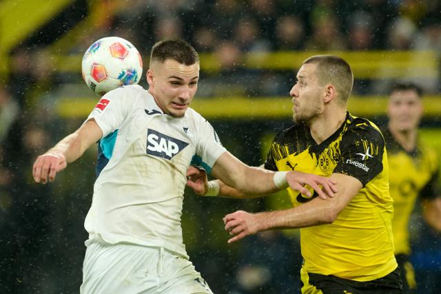 07 December 2025, North Rhine-Westphalia, Dortmund: Borussia Dortmund's Waldemar Anton (R) and Hoffenheim's Tim Lemperle battle for the ball during the German Bundesliga soccer match between Borussia Dortmund and TSG 1899 Hoffenheim at Signal Iduna Park. Photo: Bernd Thissen/dpa - IMPORTANT NOTE: In accordance with the regulations of the DFL German Football League and the DFB German Football Association, it is prohibited to utilize or have utilized photographs taken in the stadium and/or of the match in the form of sequential images and/or video-like photo series.