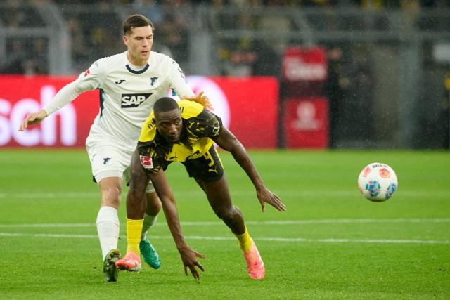 07 December 2025, North Rhine-Westphalia, Dortmund: Borussia Dortmund's Serhou Guirassy (R) and Hoffenheim's Robin Hranac battle for the ball during the German Bundesliga soccer match between Borussia Dortmund and TSG 1899 Hoffenheim at Signal Iduna Park. Photo: Bernd Thissen/dpa - IMPORTANT NOTE: In accordance with the regulations of the DFL German Football League and the DFB German Football Association, it is prohibited to utilize or have utilized photographs taken in the stadium and/or of the match in the form of sequential images and/or video-like photo series.