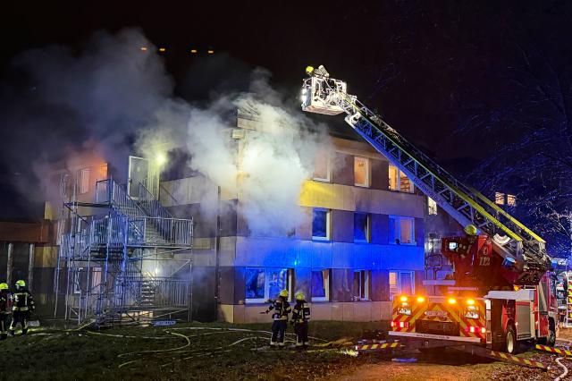 07 December 2025, North Rhine-Westphalia, Olpe: Firefighters extinguish a fire in a refugee shelter in the Olpe district. Photo: Berthold Stamm/dpa