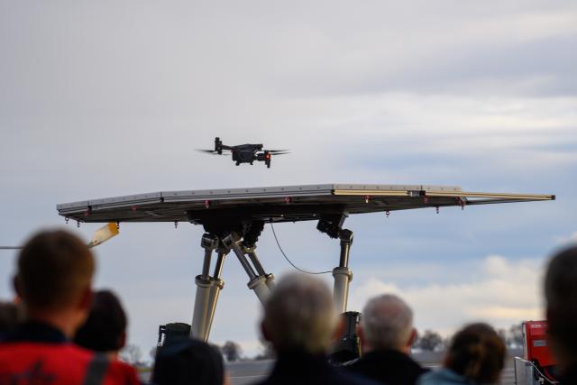 08 December 2025, Saxony-Anhalt, Cochstedt: A drone lands on the airfield of the German Aerospace Center's (DLR) National Test Center for Unmanned Aircraft Systems on a platform that simulates the flight deck of a ship in heavy seas. An event was held at the DLR Test Center for Unmanned Aircraft Systems at which DLR provided information about the prospects for drone research. Photo: Klaus-Dietmar Gabbert/dpa