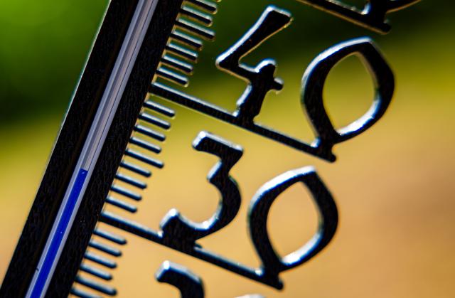 FILED - 14 August 2025, Mecklenburg-Western Pomerania, Schwerin: In front of a cloudless blue sky, an outdoor thermometer in a garden already shows an air temperature of over 30 degrees in the morning. Photo: Jens Büttner/dpa