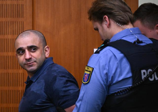 09 December 2025, Hesse, Frankfurt/Main: One of the three defendants, Russian Arman S. (L), is led into the courtroom on the opening day of the trial against three men for spying for Russia. Three men are said to have had a man in their sights for a Russian secret service. A crucial meeting is said to have been planned in a cafe in Frankfurt. Now the trial begins. Photo: -/POOL/AFP/dpa