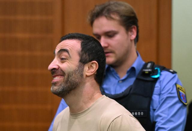 09 December 2025, Hesse, Frankfurt/Main: One of the three defendants, Armenian Vardges I. (L), is led into the courtroom on the opening day of the trial against three men for spying for Russia. Three men allegedly had a man in their sights for a Russian secret service. A crucial meeting is said to have been planned in a cafe in Frankfurt. Now the trial begins. Photo: -/POOL/AFP/dpa