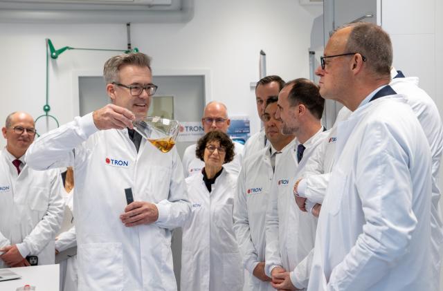 09 December 2025, Rhineland-Palatinate, Mainz: Tim Beissert (L) from TRON explains a project with yeast to German Chancellor Friedrich Merz (R) at the laboratory of TRON GmbH during his inaugural visit to Rhineland-Palatinate with Rhineland-Palatinate Health Minister Clemens Hoch. TRON gGmbH is one of the leading biomedical research institutes in Germany. Chancellor Merz is on his inaugural visit to Rhineland-Palatinate. Photo: Harald Tittel/dpa