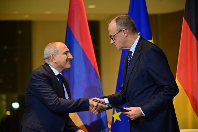 09 December 2025, Berlin: Nikol Pashinyan (L), Armenia's Prime Minister, and German Chancellor Friedrich Merz shake hands after signing a memorandum of understanding before a press conference at the German Chancellery during Pashinyan's visit. Photo: Sebastian Christoph Gollnow/dpa