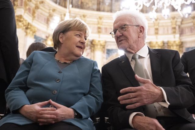 09 December 2025, Baden-Wuerttemberg, Stuttgart: Minister President of Baden-Wuerttemberg Winfried Kretschmann (R) sits with former German Chancellor Angela Merkel in the Marble Hall of the New Palace. Merkel receives the Staufer Medal in Gold for her coronavirus policy. Photo: Marijan Murat/dpa