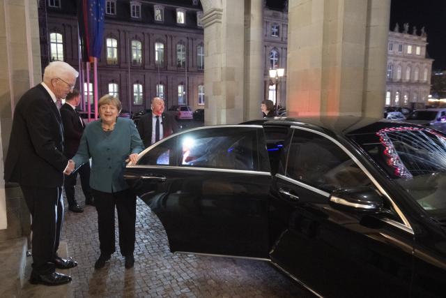 09 December 2025, Baden-Wuerttemberg, Stuttgart: Minister President of Baden-Wuerttemberg Winfried Kretschmann welcomes former German Chancellor Angela Merkel in front of the New Palace. Merkel receives the Staufer Medal in Gold for her coronavirus policy. Photo: Marijan Murat/dpa
