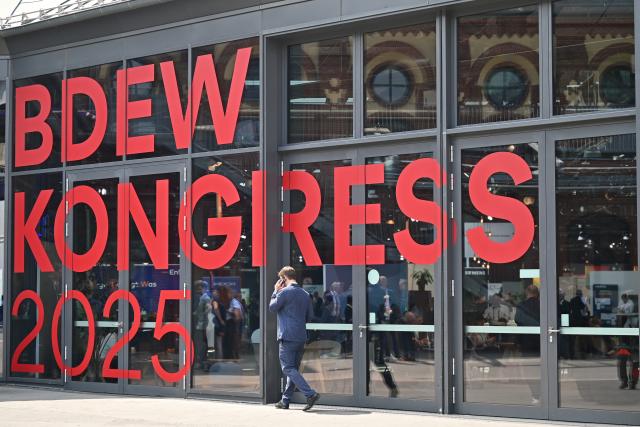 FILED - 04 June 2025, Berlin: A man walks along a telephone in front of a sign at the entrance to the BDEW Congress 2025, the industry meeting of the German Association of Energy and Water Industries, at Berlin Station. Photo: Katharina Kausche/dpa