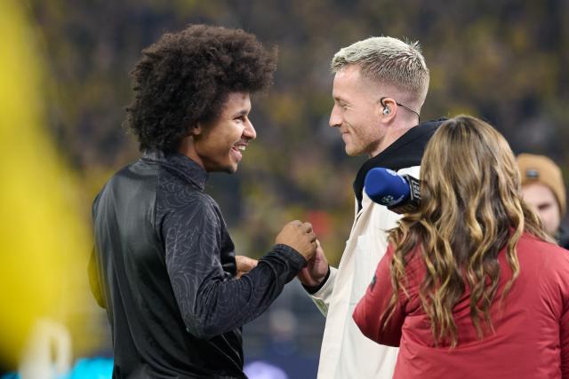 10 December 2025, North Rhine-Westphalia, Dortmund: Borussia Dortmund's Karim Adeyemi (L) welcomes former Dortmund player Marco Reus, who is covering the match as a pundit for the TV channel DAZN, prior to the start of the UEFA Champions League soccer match between Borussia Dortmund and FK Bodoe/Glimt at Signal Iduna Park. Photo: Bernd Thissen/dpa