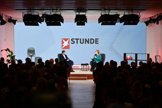 11 December 2025, Berlin: Gregor Peter Schmitz, editor-in-chief of Stern, and former German Chancellor Angela Merkel speak during the "Stern Stunde" talk at the Bertelsmann Representative Office. Photo: Sebastian Christoph Gollnow/dpa