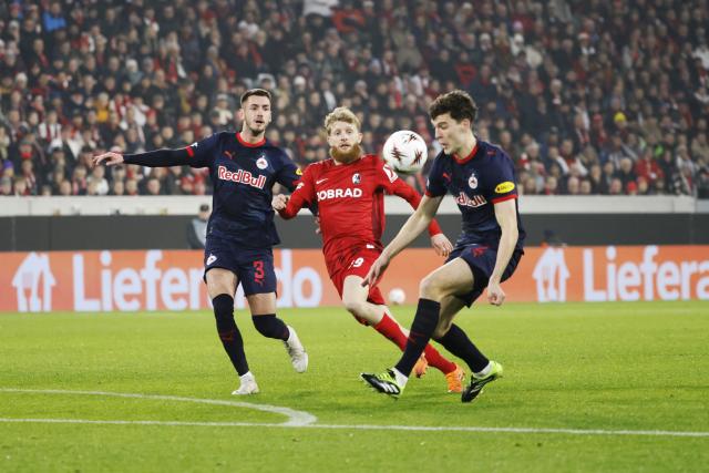 11 December 2025, Baden-Wuerttemberg, Freiburg im Breisgau: Freiburg's Jan-Niklas Beste (C) battles for the ball with Salzburg's Jacob Rasmussen (R) and Aleksa Terzic during the UEFA Europa League soccer match between SC Freiburg and RB Salzburg at Europa-Park Stadium. Photo: Philipp von Ditfurth/dpa