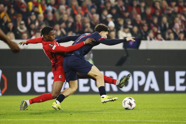 11 December 2025, Baden-Wuerttemberg, Freiburg im Breisgau: Freiburg's Junior Adamu (L) and Salzburg's Clement Bischoff battle for the ball during the UEFA Europa League soccer match between SC Freiburg and RB Salzburg at Europa-Park Stadium. Photo: Philipp von Ditfurth/dpa