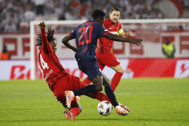 11 December 2025, Baden-Wuerttemberg, Freiburg im Breisgau: Salzburg's Edmund Baidoo (C) battles for the ball with Freiburg's Johan Manzambi (L) and Christian Guenter during the UEFA Europa League soccer match between SC Freiburg and RB Salzburg at Europa-Park Stadium. Photo: Philipp von Ditfurth/dpa