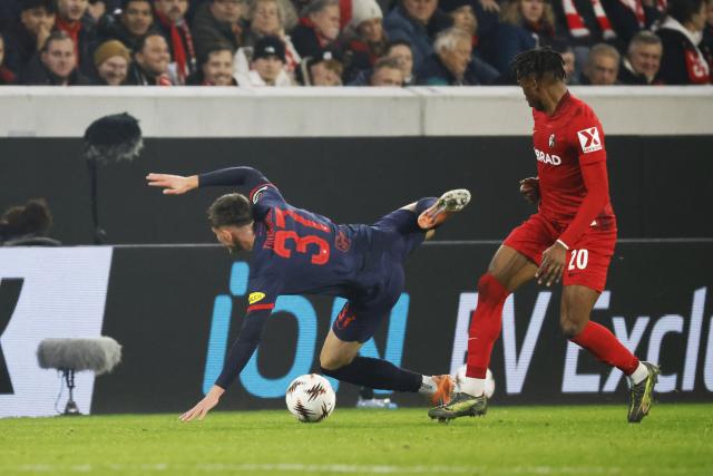 11 December 2025, Baden-Wuerttemberg, Freiburg im Breisgau: RB Salzburg's Tim Trummer (L) and Freiburg's Junior Adamu battle for the ball during the UEFA Europa League soccer match between SC Freiburg and RB Salzburg at Europa-Park Stadium. Photo: Philipp von Ditfurth/dpa