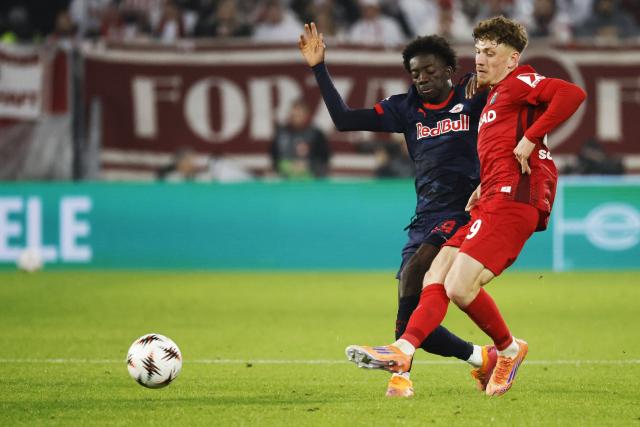 11 December 2025, Baden-Wuerttemberg, Freiburg im Breisgau: RB Salzburg's Moussa Yeo (L) and Freiburg's Philipp Treu battle for the ball during the UEFA Europa League soccer match between SC Freiburg and RB Salzburg at Europa-Park Stadium. Photo: Philipp von Ditfurth/dpa