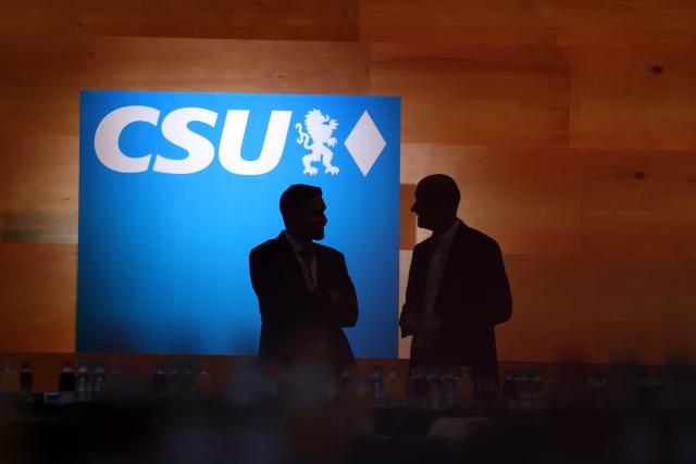 12 December 2025, Bavaria, Munich: Visitors to the CSU party conference stand in front of the podium. Photo: Karl-Josef Hildenbrand/dpa