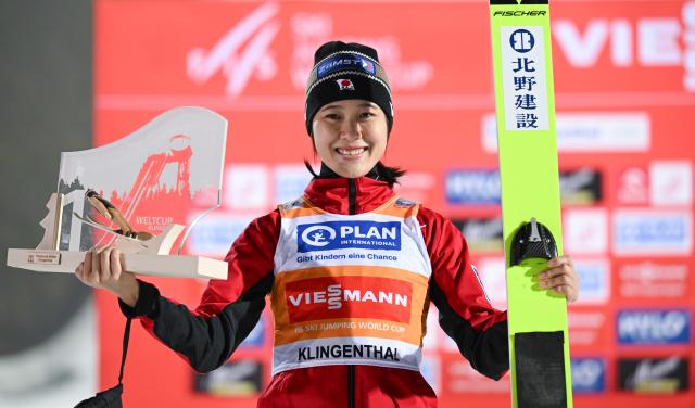 12 December 2025, Saxony, Klingenthal: Japanese ski jumper Nozomi Maruyama celebrates with her trophy at the award ceremony after winning the women's large hill 2nd round of the FIS Ski Jumping World Cup in Klingenthal. Photo: Hendrik Schmidt/dpa