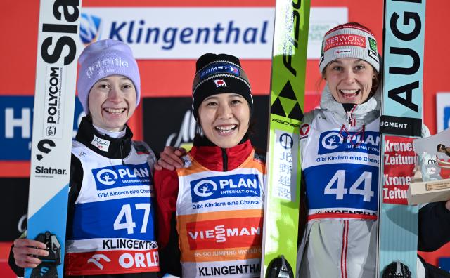 12 December 2025, Saxony, Klingenthal: (L-R) Slovenia's second placed Nika Prevc, Japan's winner Nozomi Maruyama and Austria's third placed Lisa Eder celebrate at the award ceremony after the women's large hill 2nd round of the FIS Ski Jumping World Cup in Klingenthal. Photo: Hendrik Schmidt/dpa