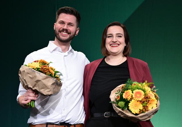 12 December 2025, Baden-Wuerttemberg, Ludwigsburg: Lena Schwelling (R) and Pascal Haggenmueller, the re-elected state executive committee members of the Alliance 90/The Greens (Bündnis 90/Die Grünen) Baden-Wuerttemberg party, 
stand on the podium at the state party conference after the election. Photo: Bernd Weißbrod/dpa