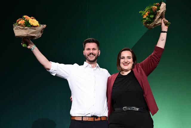 12 December 2025, Baden-Wuerttemberg, Ludwigsburg: Lena Schwelling (R) and Pascal Haggenmueller, the re-elected state executive committee members of the Alliance 90/The Greens (Bündnis 90/Die Grünen) Baden-Wuerttemberg party, 
stand on the podium at the state party conference after the election. Photo: Bernd Weißbrod/dpa