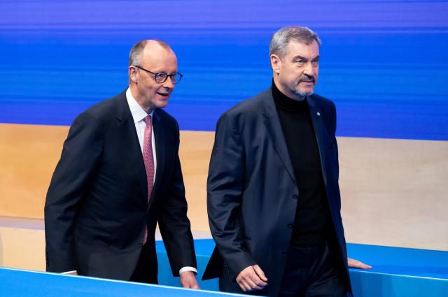 13 December 2025, Bavaria, Munich: Markus Soeder (r), CSU Chairman and Minister President of Bavaria, and German Chancellor Friedrich Merz (CDU) take to the stage at the CSU party conference in the exhibition hall. Photo: Sven Hoppe/dpa