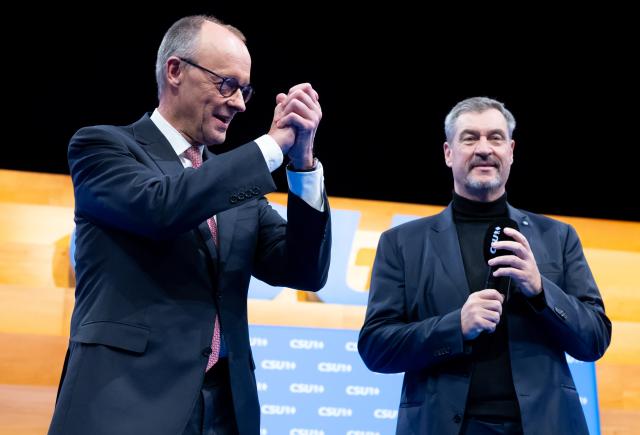 13 December 2025, Bavaria, Munich: Markus Soeder (r), CSU Chairman and Minister President of Bavaria, and German Chancellor Friedrich Merz, on stage at the CSU party conference in the exhibition hall. Photo: Sven Hoppe/dpa