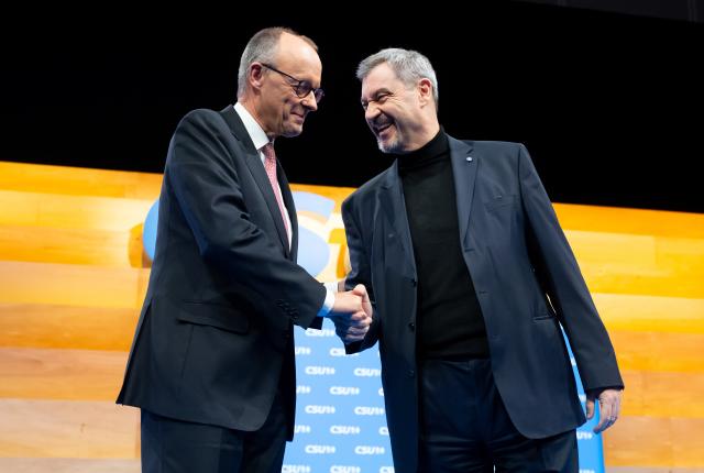 13 December 2025, Bavaria, Munich: Markus Soeder (r), CSU Chairman and Minister President of Bavaria, and German Chancellor Friedrich Merz, on stage at the CSU party conference in the exhibition hall. Photo: Sven Hoppe/dpa