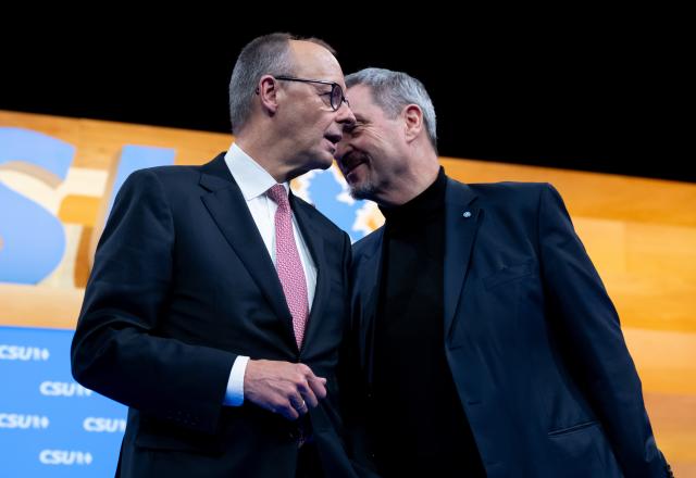 13 December 2025, Bavaria, Munich: Markus Soeder (r), CSU Chairman and Minister President of Bavaria, and German Chancellor Friedrich Merz on stage at the CSU party conference in the exhibition hall. Photo: Sven Hoppe/dpa