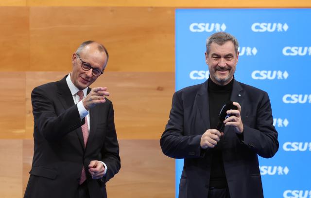 13 December 2025, Bavaria, Munich: German Chancellor Friedrich Merz (L) and Markus Soeder, CSU Chairman and Bavarian Minister President, stand on stage at the party conference after the Chancellor's speech. Photo: Karl-Josef Hildenbrand/dpa