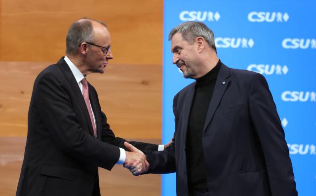 13 December 2025, Bavaria, Munich: German Chancellor Friedrich Merz (L) and Markus Soeder, CSU Chairman and Bavarian Minister President, stand on stage at the party conference after the Chancellor's speech. Photo: Karl-Josef Hildenbrand/dpa