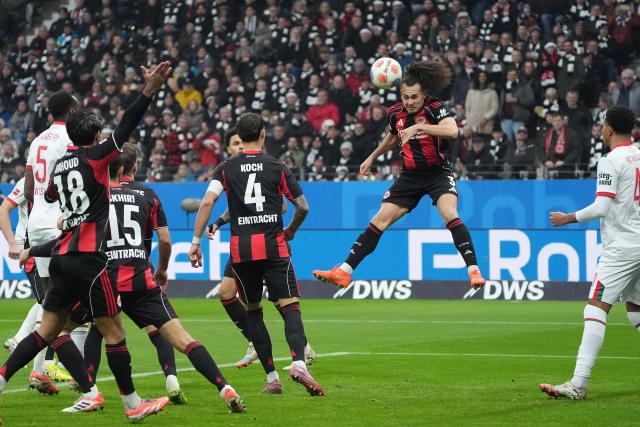 13 December 2025, Hesse, Frankfurt/M.: Eintracht Frankfurt's Arthur Theate (2nd R) in action during the German Bundesliga soccer match between Eintracht Frankfurt and FC Augsburg at Deutsche Bank Park. Photo: Marc Schüler/dpa - WICHTIGER HINWEIS: Gemäß den Vorgaben der DFL Deutsche Fußball Liga bzw. des DFB Deutscher Fußball-Bund ist es untersagt, in dem Stadion und/oder vom Spiel angefertigte Fotoaufnahmen in Form von Sequenzbildern und/oder videoähnlichen Fotostrecken zu verwerten bzw. verwerten zu lassen.