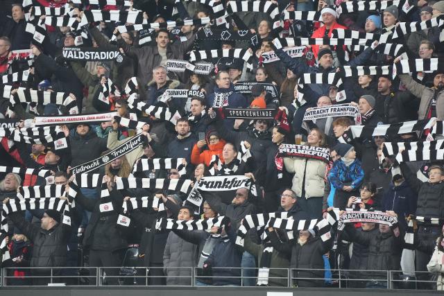 13 December 2025, Hesse, Frankfurt/M.: Eintracht fans cheer with scarves in the stands during the German Bundesliga soccer match between Eintracht Frankfurt and FC Augsburg at Deutsche Bank Park. Photo: Marc Schüler/dpa - WICHTIGER HINWEIS: Gemäß den Vorgaben der DFL Deutsche Fußball Liga bzw. des DFB Deutscher Fußball-Bund ist es untersagt, in dem Stadion und/oder vom Spiel angefertigte Fotoaufnahmen in Form von Sequenzbildern und/oder videoähnlichen Fotostrecken zu verwerten bzw. verwerten zu lassen.