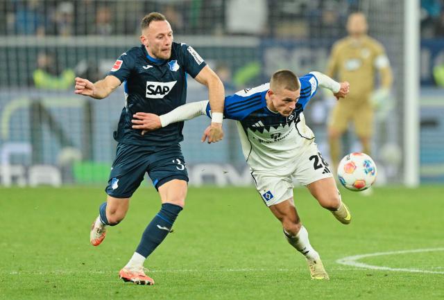 13 December 2025, Baden-Wuerttemberg, Sinsheim: Hamburger's Miro Muheim (R) and Hoffenheim's Vladimir Coufal battle for the ball during the German Bundesliga soccer match between TSG 1899 Hoffenheim and Hamburger SV at PreZero Arena. Photo: Uwe Anspach/dpa - WICHTIGER HINWEIS: Gemäß den Vorgaben der DFL Deutsche Fußball Liga bzw. des DFB Deutscher Fußball-Bund ist es untersagt, in dem Stadion und/oder vom Spiel angefertigte Fotoaufnahmen in Form von Sequenzbildern und/oder videoähnlichen Fotostrecken zu verwerten bzw. verwerten zu lassen.