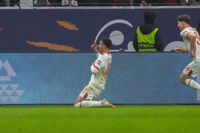 13 December 2025, Hesse, Frankfurt/M.: Augsburg's Noahkai Banks (L) celebrates scoring his side's first goal during the German Bundesliga soccer match between Eintracht Frankfurt and FC Augsburg at Deutsche Bank Park. Photo: Marc Schüler/dpa - WICHTIGER HINWEIS: Gemäß den Vorgaben der DFL Deutsche Fußball Liga bzw. des DFB Deutscher Fußball-Bund ist es untersagt, in dem Stadion und/oder vom Spiel angefertigte Fotoaufnahmen in Form von Sequenzbildern und/oder videoähnlichen Fotostrecken zu verwerten bzw. verwerten zu lassen.