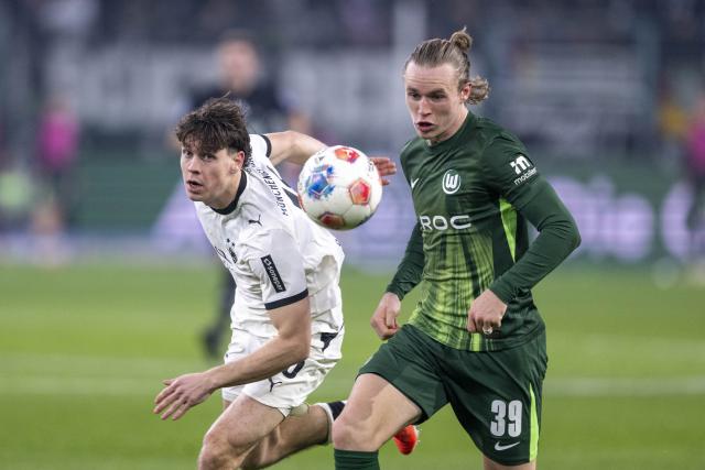 13 December 2025, North Rhine-Westphalia, Moenchengladbach: Borussia Moenchengladbach Philipp Sander (L) and Wolfsburg's Patrick Wimmer battle for the ball during the German Bundesliga soccer match between Borussia Moenchengladbach and VfL Wolfsburg at Stadion im Borussia-Park. Photo: David Inderlied/dpa - WICHTIGER HINWEIS: Gemäß den Vorgaben der DFL Deutsche Fußball Liga bzw. des DFB Deutscher Fußball-Bund ist es untersagt, in dem Stadion und/oder vom Spiel angefertigte Fotoaufnahmen in Form von Sequenzbildern und/oder videoähnlichen Fotostrecken zu verwerten bzw. verwerten zu lassen.