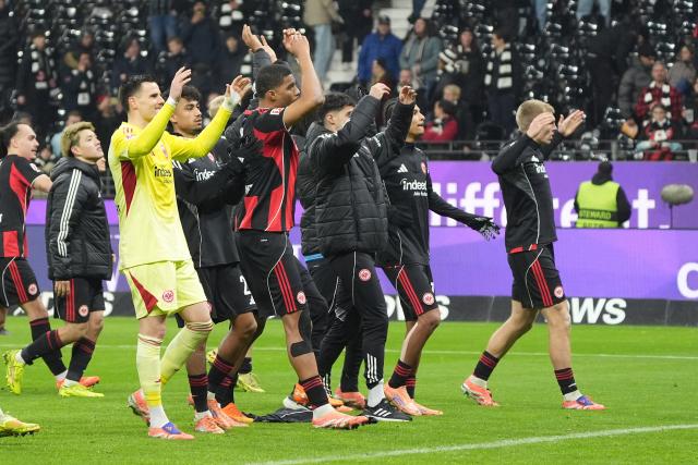 13 December 2025, Hesse, Frankfurt/M.: Eintracht Frankfurt players celebrate with the fans after the German Bundesliga soccer match between Eintracht Frankfurt and FC Augsburg at Deutsche Bank Park. Photo: Marc Schüler/dpa - WICHTIGER HINWEIS: Gemäß den Vorgaben der DFL Deutsche Fußball Liga bzw. des DFB Deutscher Fußball-Bund ist es untersagt, in dem Stadion und/oder vom Spiel angefertigte Fotoaufnahmen in Form von Sequenzbildern und/oder videoähnlichen Fotostrecken zu verwerten bzw. verwerten zu lassen.