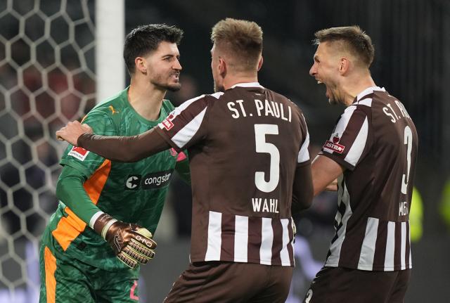13 December 2025, Hamburg: St. Pauli's Karol Mets (R), Hauke Wahl (C) and goalkeeper Nikola Vasilj celebrate after the German Bundesliga soccer match between FC St. Pauli and 1. FC Heidenheim at Millerntor Stadium. Photo: Marcus Brandt/dpa - WICHTIGER HINWEIS: Gemäß den Vorgaben der DFL Deutsche Fußball Liga bzw. des DFB Deutscher Fußball-Bund ist es untersagt, in dem Stadion und/oder vom Spiel angefertigte Fotoaufnahmen in Form von Sequenzbildern und/oder videoähnlichen Fotostrecken zu verwerten bzw. verwerten zu lassen.