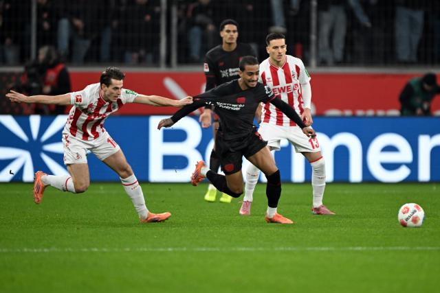 13 December 2025, North Rhine-Westphalia, Leverkusen: Cologne's Jakub Kaminski (L) and Bayer Leverkusen's Arthur battle for the ball during the German Bundesliga soccer match between Bayer Leverkusen and 1. FC Cologne at BayArena. Photo: Federico Gambarini/dpa - WICHTIGER HINWEIS: Gemäß den Vorgaben der DFL Deutsche Fußball Liga bzw. des DFB Deutscher Fußball-Bund ist es untersagt, in dem Stadion und/oder vom Spiel angefertigte Fotoaufnahmen in Form von Sequenzbildern und/oder videoähnlichen Fotostrecken zu verwerten bzw. verwerten zu lassen.